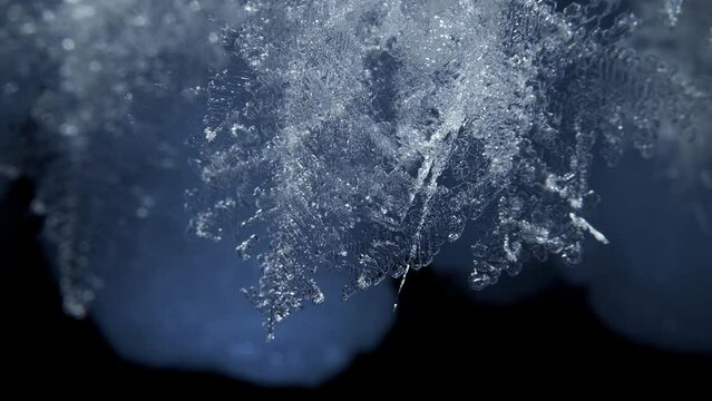 Beautiful crystal icicles, blue sharp ice snowflakes on stalactites inside cave 