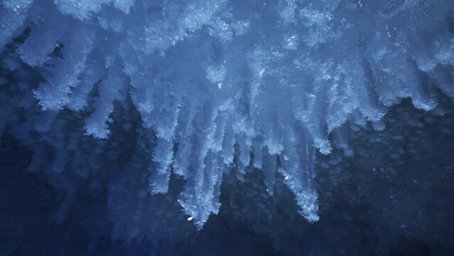 Beautiful crystal icicles, blue sharp ice floes inside frozen cave