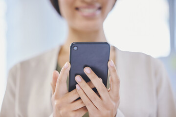 In business, you should always stay updated with the latest news. Cropped shot of a businesswoman using her cellphone.