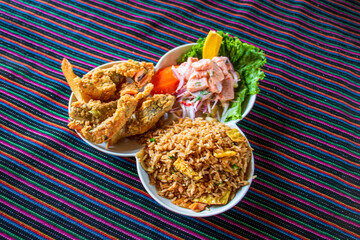 Peruvian food Trio marine chaufa rice ceviche fish pork rinds Traditional food on a lliclla
