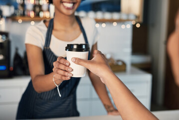 Collecting a fresh cup of the best. Closeup shot of a barista serving coffee to a customer in a cafe.