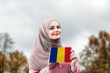 Muslim woman in hijab holds flag of Romania