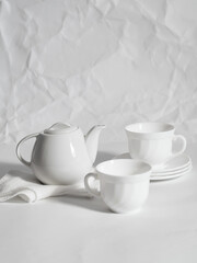 Obraz na płótnie Canvas minimalistic white porcelain teapot and cups for tea drinking for two