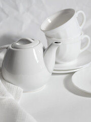 minimalistic white porcelain teapot and cups for tea drinking for two