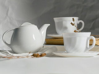 minimalistic white porcelain teapot and cups for tea drinking for two