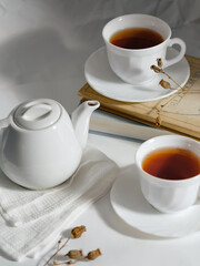 minimalistic white porcelain teapot and cups for tea drinking for two