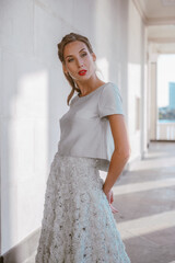 Stylish bride in long light blue taffeta dress and decorated with handmade flowers walks...