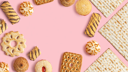 Various kosher pastries for Jewish holiday Pesach on pink background with copy space.