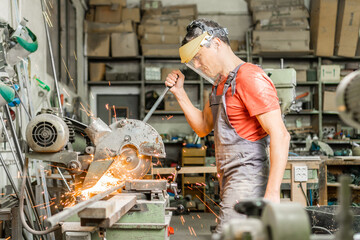 Handyman operating steel cutter machine in workshop