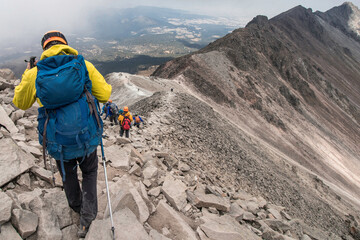 group of hiker descending the edge of a rocky mountain in the Nevado de Toluca in Mexico