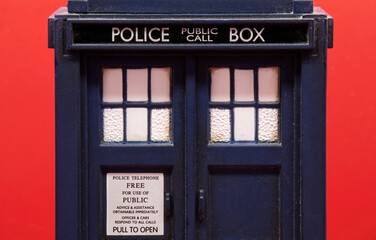 Obraz premium Police call box isolated on red background. Tardis from Doctor Who. Close-up