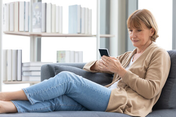 Obraz premium senior woman using smartphone for work in free time
