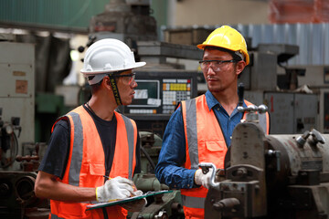 Asian male engineer team monitors and control Planning for maintenance of metalworking machines in industrial plants,