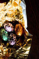 Easter eggs wrapped with aluminum foil on a gold-colored material