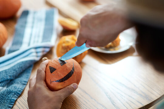 Tapping into the Halloween spirit. Shot of an unrecognizable person carving a pumpkin at home.