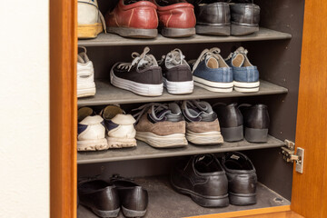 木製の靴箱に収納されたたくさんの靴