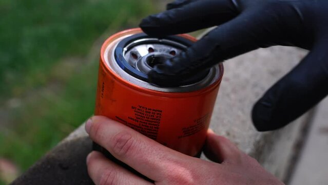 Adding oil to a new oil filter for automotive service work on a truck's oil change.