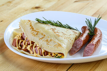 Pancake with sliced sausage and mustard