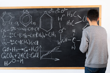 arabic chemistry teacher writing formulas on blackboard, chemistry lecture at university, education and science for youth