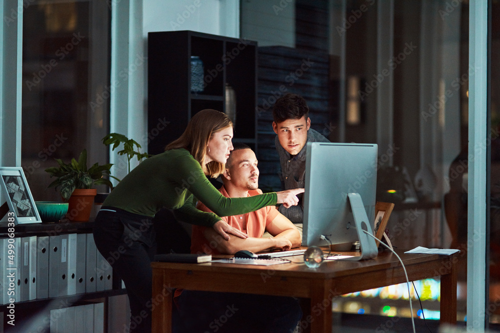 Poster The internet is there to make things easier. Shot of a group of designers looking at something on a computer while working late.