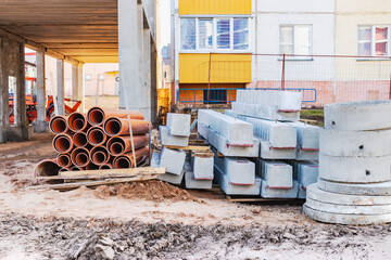 Concrete well rings and slabs at construction site.