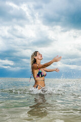 beautiful woman in bikini in the sea playing with water, hermosa mujer en bikini en el mar jugando con el agua
