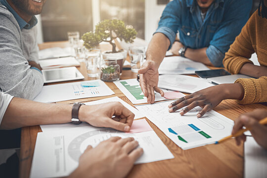 Getting To The Root In A Timely Manner. Shot Of A Group Of Businesspeople Discussing Statistics.