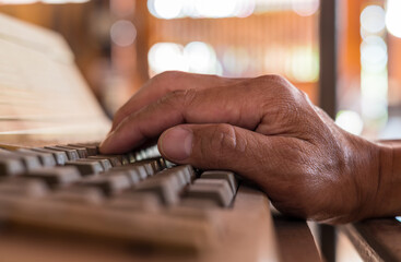 Close-up view of one hand resting on the keyboard.