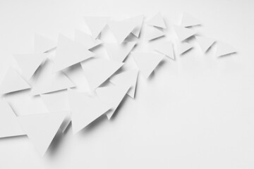 Wave of white paper triangles flying in bright light with soft light shadows as energy curved flow, border, copy space, top view. Minimalist softness delicate airy active modern abstract background.