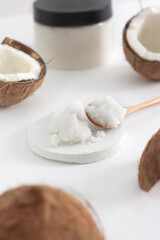 scrub in wood spoon with jar coconut on white background. Home spa treatment concept, organic cosmetic. Vertical photo