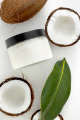 fresh scrub in jar with coconut on white background. Home spa treatment concept, organic cosmetic. Vertical photo