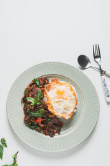 Thailand Food : Stir-fried beef and basil with fried egg on green plate Thai food concept.Thai street food