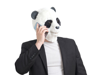 Man wearing a panda mask head and a suit speaking on the smartphone, isolated.