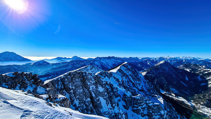 Scenic view from the summit of mount Hochobir on snow capped mountain peaks in the Karawanks in Carinthia, Austria. Winter wonderland on sunny day in Austrian Alps, Europe. Ski tour, snow shoe hiking.