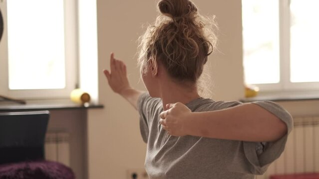 Woman practicing qigong at her cozy apartment