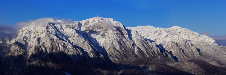 Fototapeta na wymiar Bucegi mountains and Caraiman cross top in winter season, Romania.
