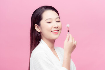 Woman caring of her beauty face with cosmetic tool. Skin care concept. Girl holds item for makeup.