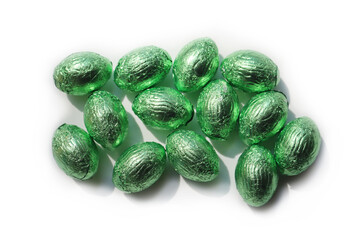 Chocolate easter eggs in green colorful foil isolated on white background