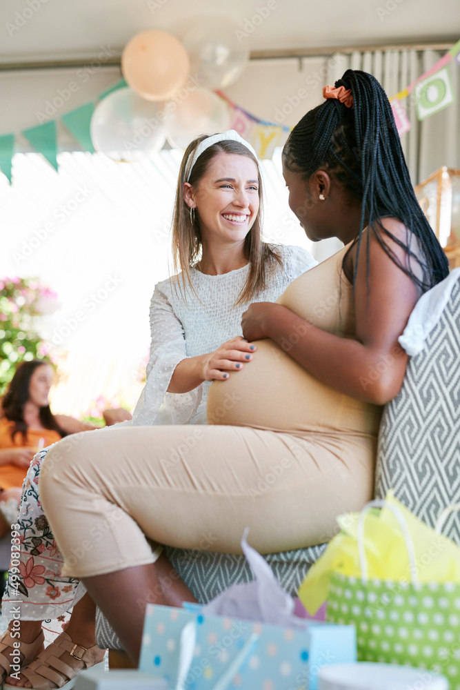 Poster do you think id be able to feel them. shot of two women relaxing during a baby shower.