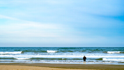 Fototapeta na wymiar Mann steht einsam am Strand