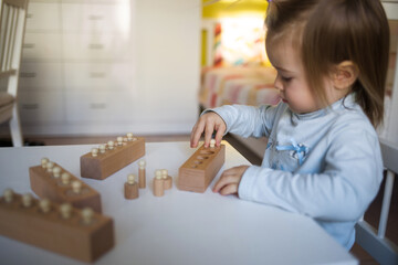 baby child plays wooden toy to develop eye and fine motor skills, determine size. toddler at home