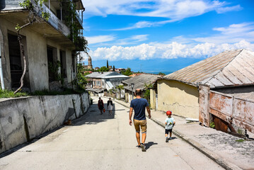 A man with a small child walking through the streets of Sighnaghi, Georgia. May 2019. Alazani Valley.