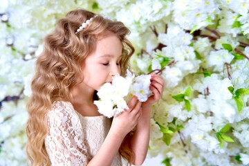 Obraz na płótnie Canvas Happy beautiful cute little blonde girl child kid in blooming garden apple trees at spring sunny day, breathing deep deeply fresh air smelling enjoying smell of flowering blossom flowers, springtime
