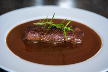 ready to eat, grilled game meat from the roe deer with brown sauce and rosemary