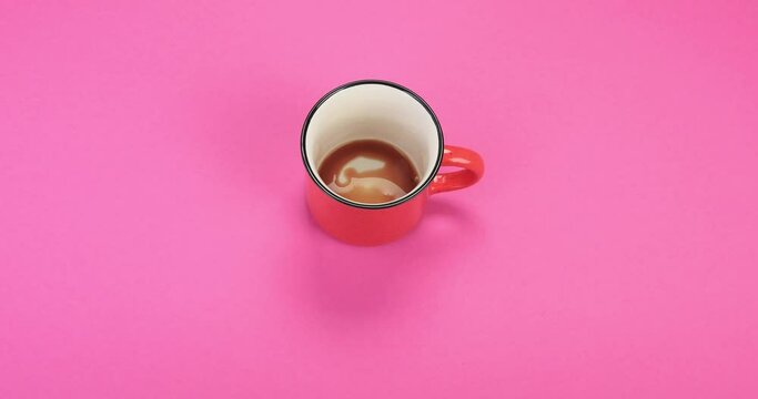 Coffee cup rotating on pink background.  Concept of time coffee, energy, power. Stop motion. Top view. Animation, 4k 