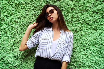 Shes confidence personified. Cropped shot of an attractive young woman standing against a green...