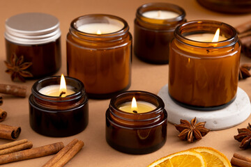 A set of different aroma candles in brown glass jars. Scented handmade candle. Soy candles are burning in a jar. Aromatherapy and relax in spa and home.