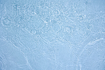 Transparent blue clear water surface texture with ripples, splashes and bubbles. Abstract nature background Water waves in sunlight. Cosmetic moisturizer micellar toner emulsion. Top view, copy space