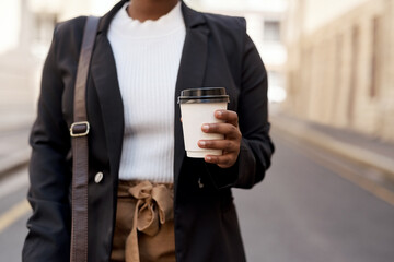 I always grab a fresh cup before starting my commute. Closeup shot of an unrecognisable businesswoman holding a coffee cup while out in the city.