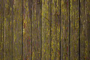 Grunge wooden background of wall with panels covered with yellow peeling paint 